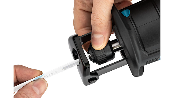 Nahaufnahme einer Hand, die ein S&auml;geblatt in die Akku-S&auml;bels&auml;ge 9534-10 einsetzt. Der Schnellspannmechanismus erleichtert den Werkzeugwechsel. Der Hintergrund bleibt neutral.