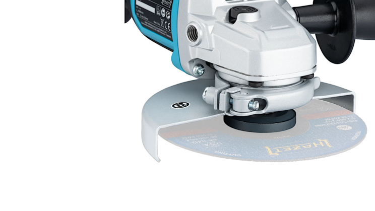 Detailaufnahme der Schleifscheibe des Akku-Winkelschleifers 9533-10. Die silberne Schutzhaube umgibt die rotierende Scheibe und sorgt f&uuml;r Sicherheit. Der Hintergrund bleibt unauff&auml;llig.